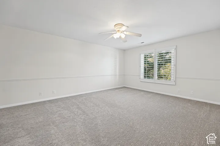 Recessed lighting, ceiling fan, carpeting, window with plantation shutters, and chair rail molding