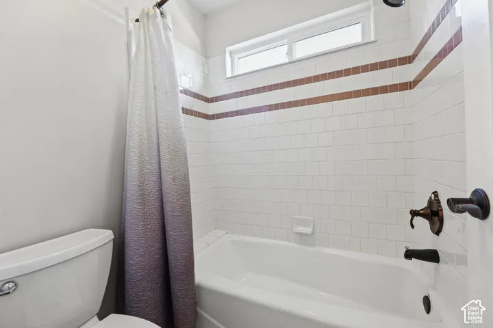 White subway tile surround with decorative accent bands, built-in bathtub, and oil-rubbed bronze fixtures
