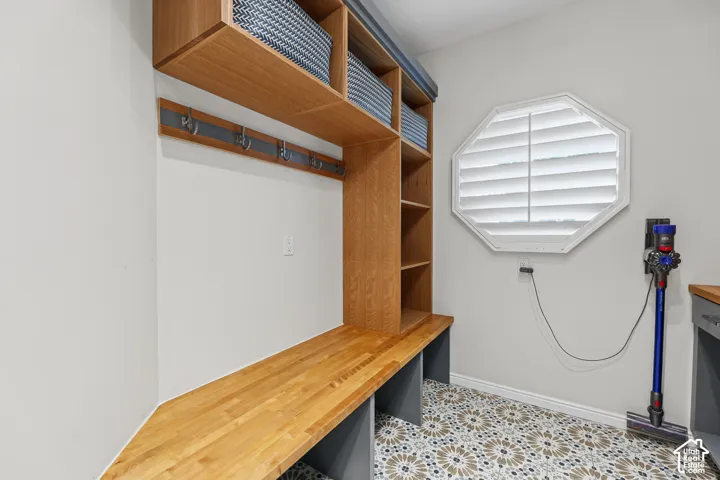 Built-in wood-finish shelving and bench with integrated coat hooks