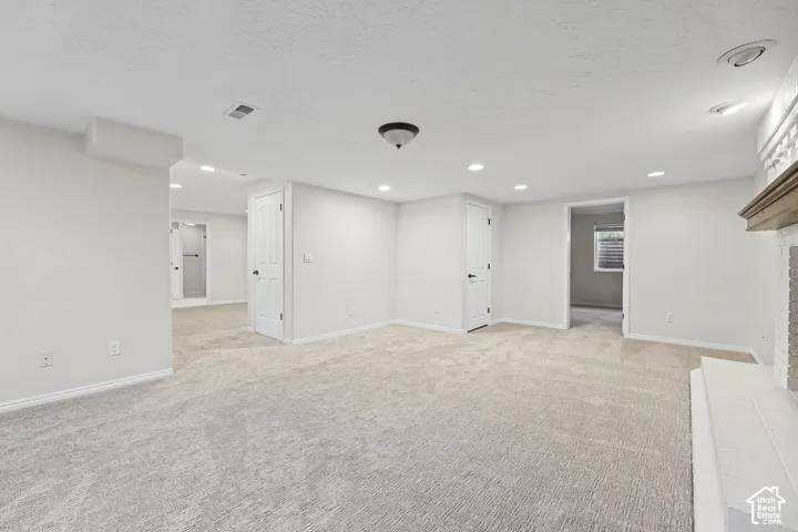 Spacious room with light-toned carpeting and recessed lighting