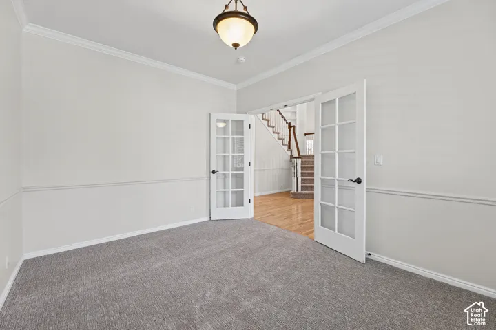 Room featuring crown molding, chair rail molding, and a carpeted floor