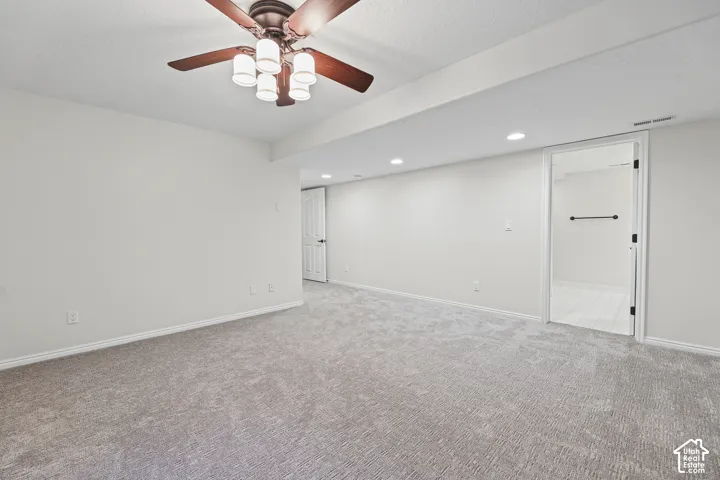 Spacious room with gray carpet flooring and recessed lighting