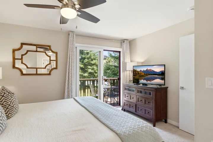 Bedroom featuring neutral-toned walls, carpeting, and a ceiling fan with integrated lighting