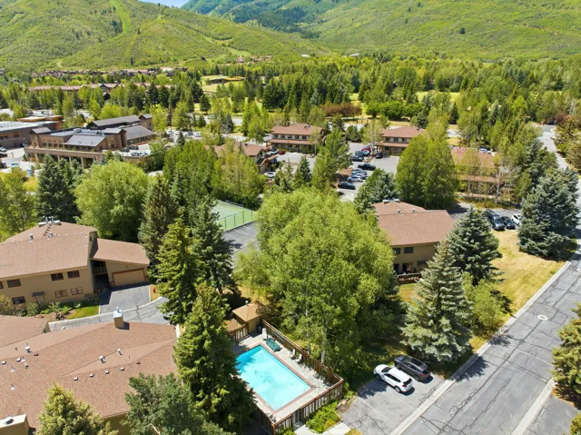 Community amenities including a swimming pool with a surrounding deck, a tennis court, and multiple parking areas
