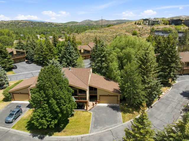 Contemporary multi-level residence featuring a brown shingle roof, attached two-car garage, and a raised exterior deck