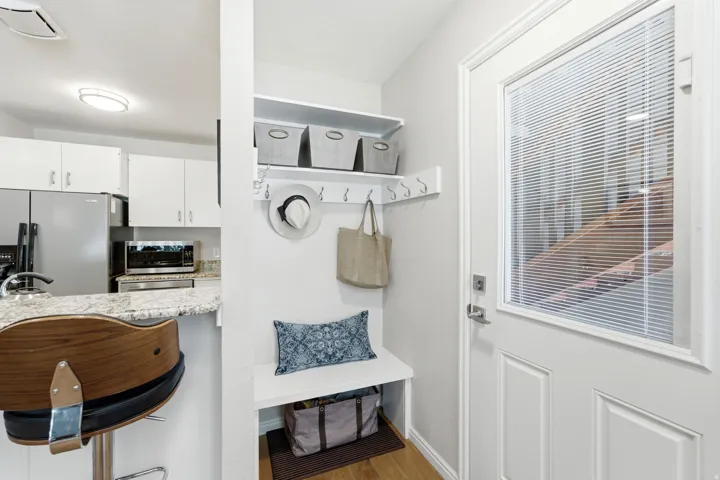 Entryway featuring a built-in bench, upper shelving, and wall hooks