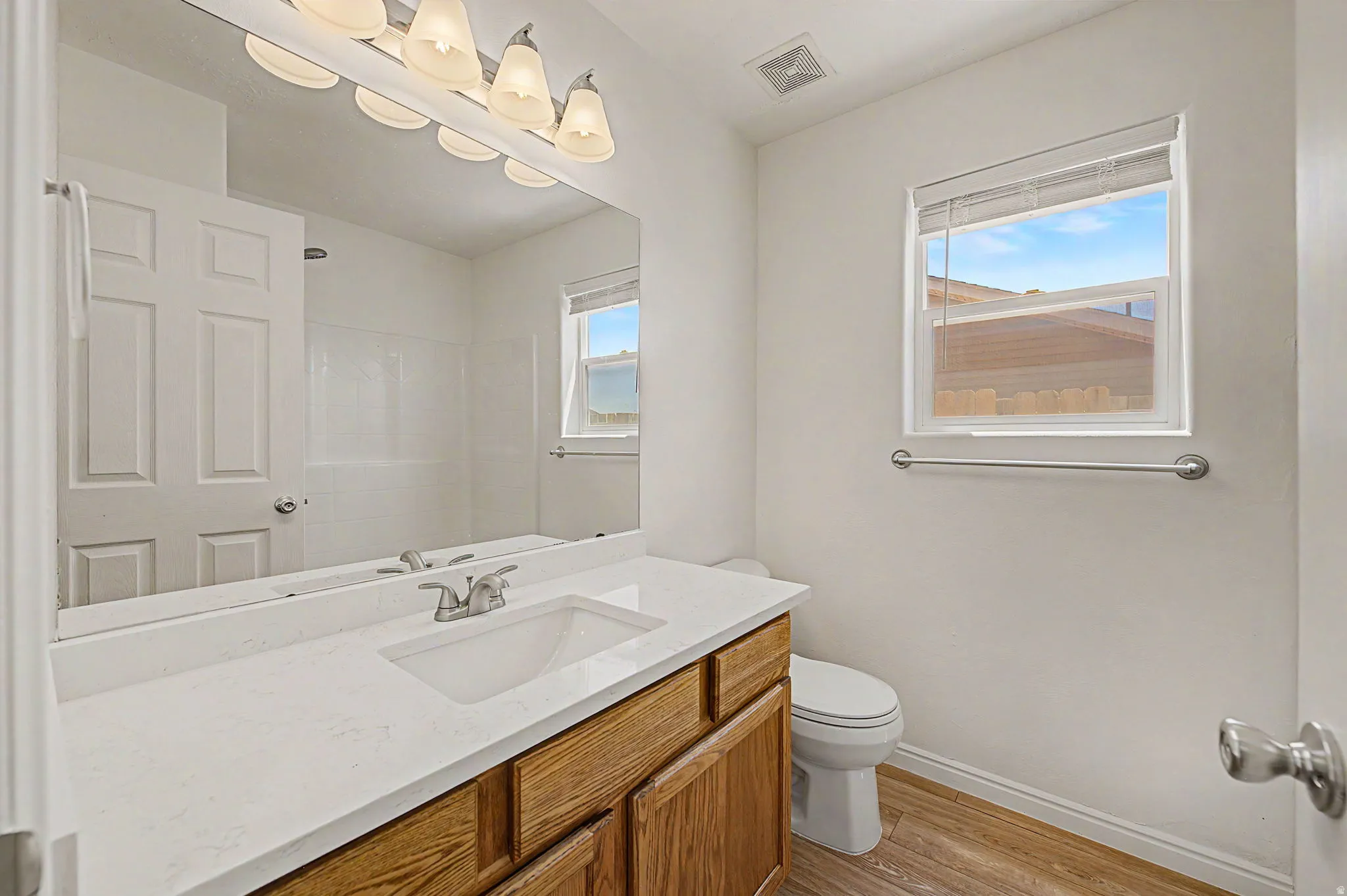 Bathroom featuring a light wood-finish vanity with a white countertop and integrated sink