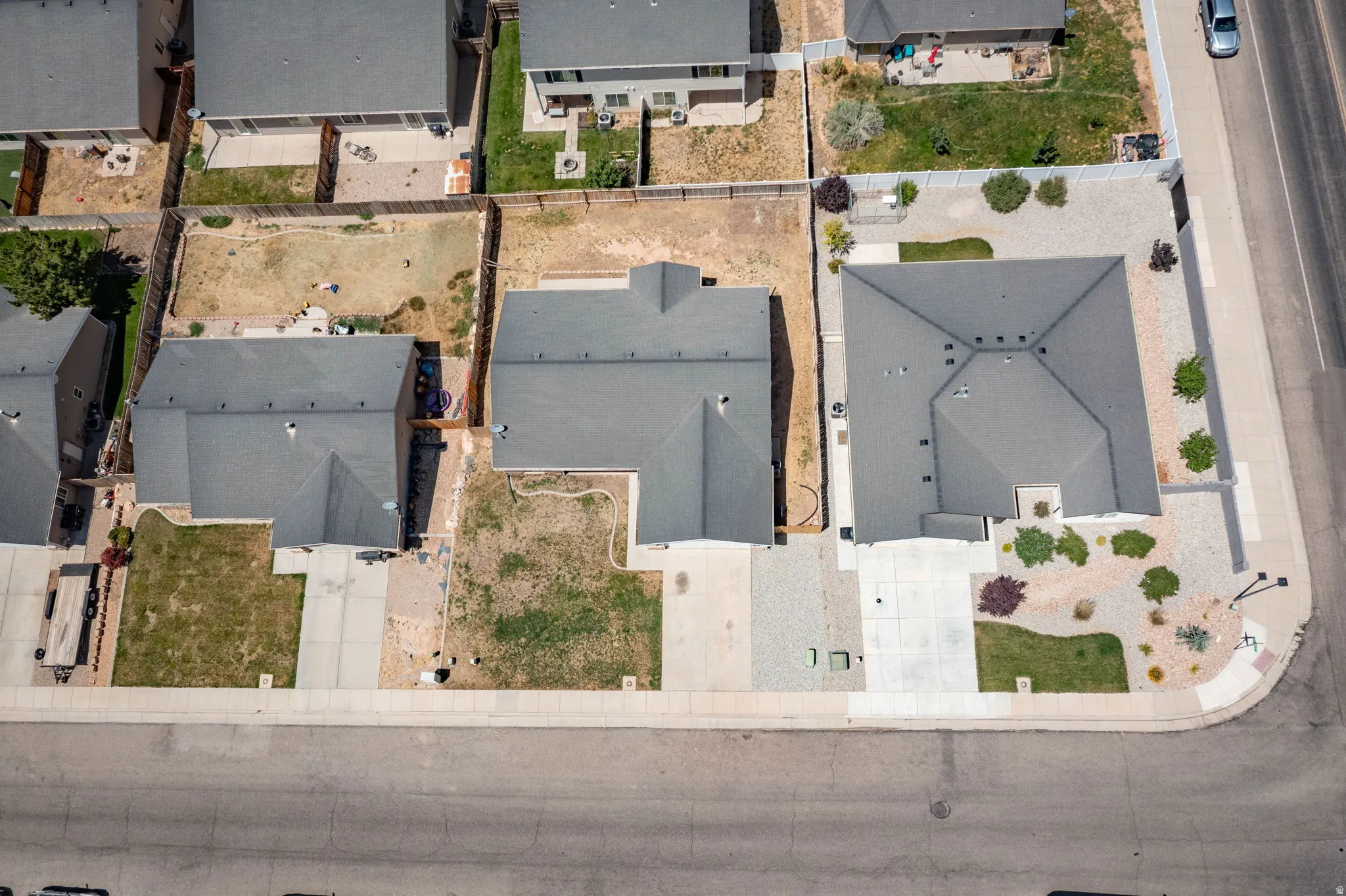 Aerial perspective highlighting three residential properties with gray shingle roofs