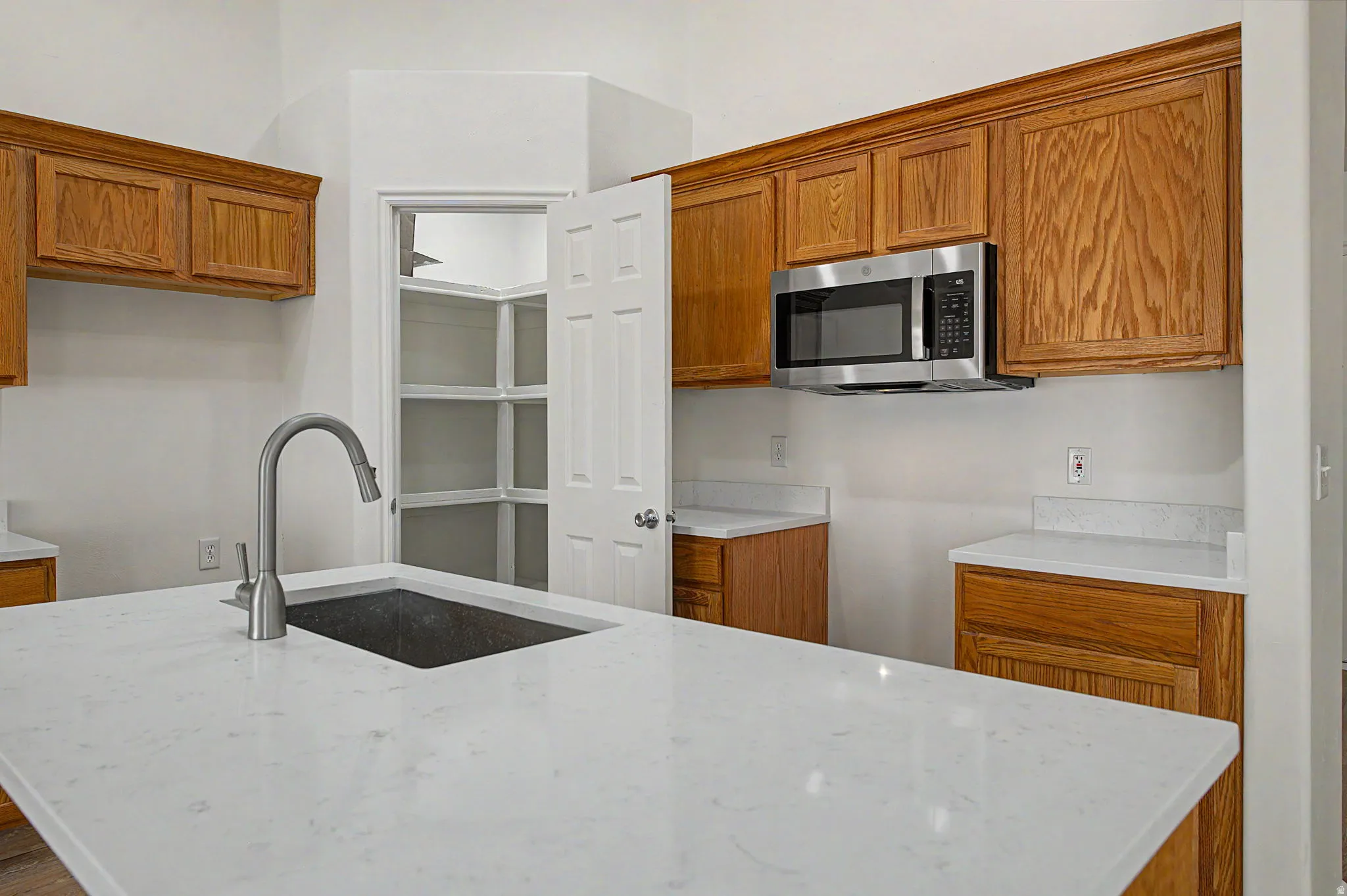 Kitchen featuring a large central island with an undermount sink and gooseneck faucet