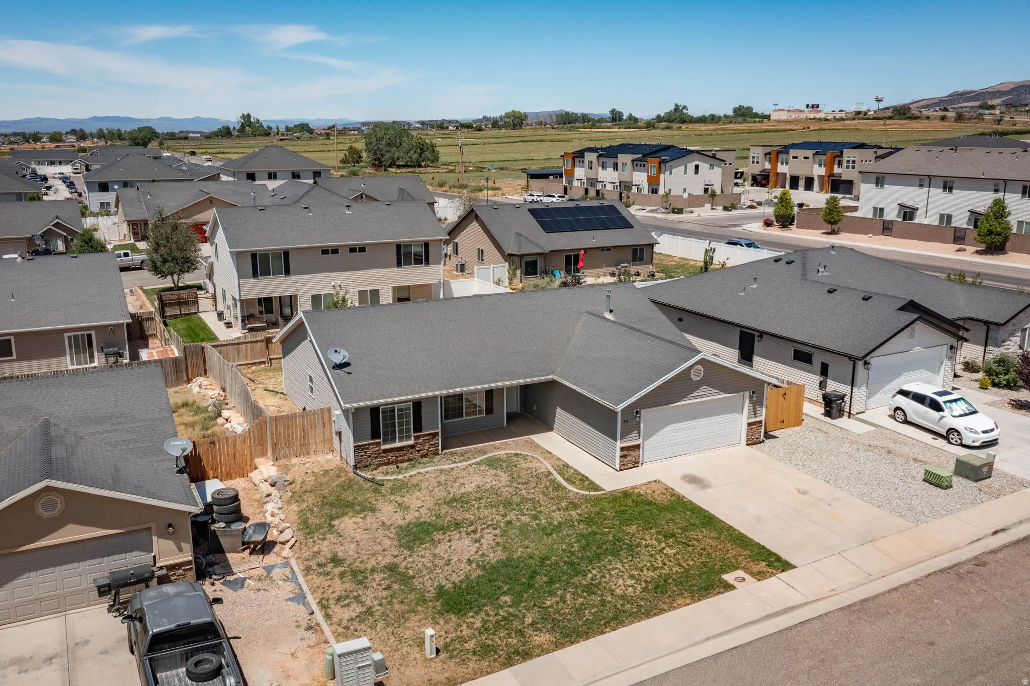 Single-story residence featuring a gray exterior with stone accents and a dark shingle roof