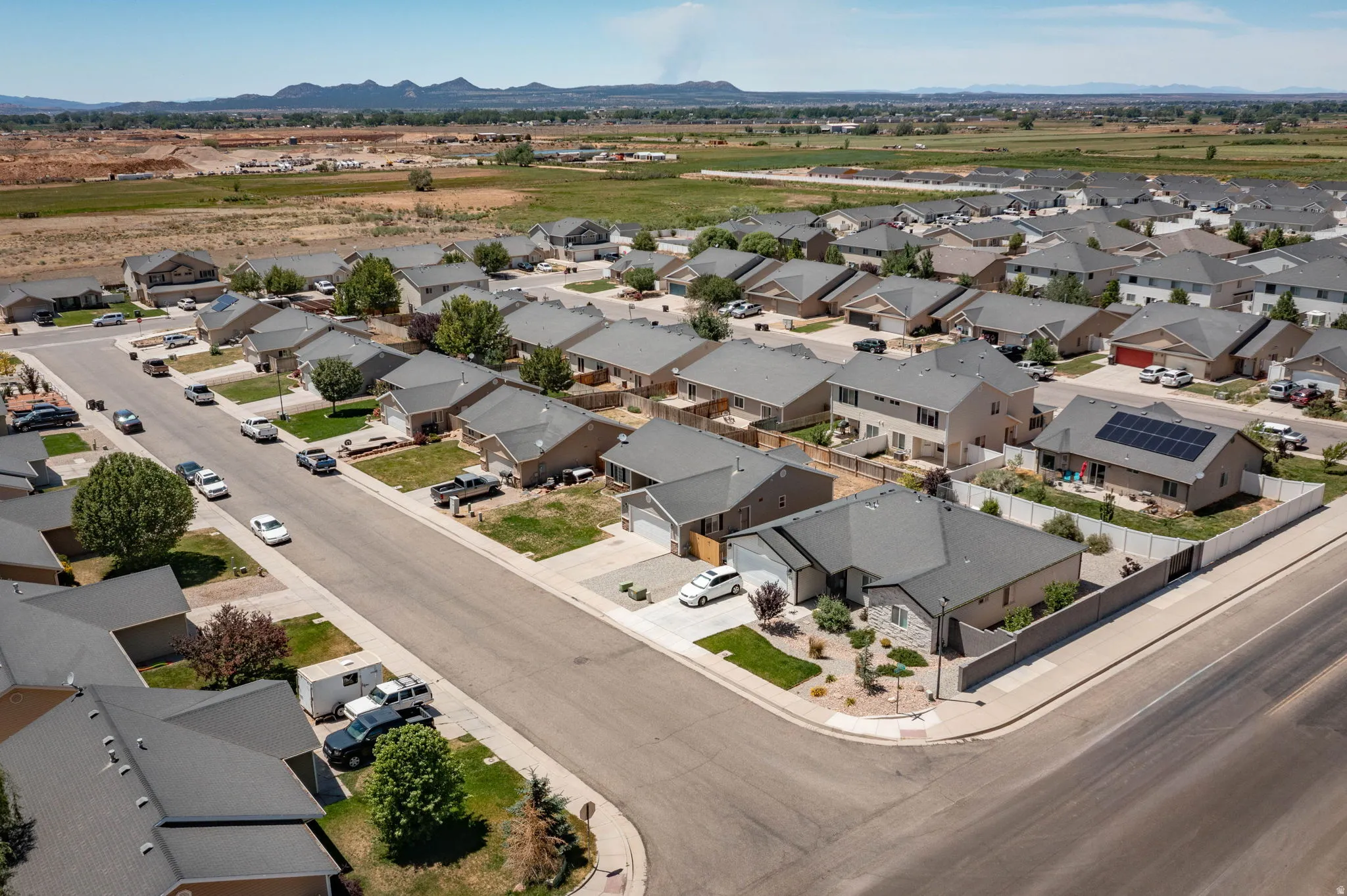 Aerial view of a residential neighborhood with detached homes featuring gray asphalt shingle roofs