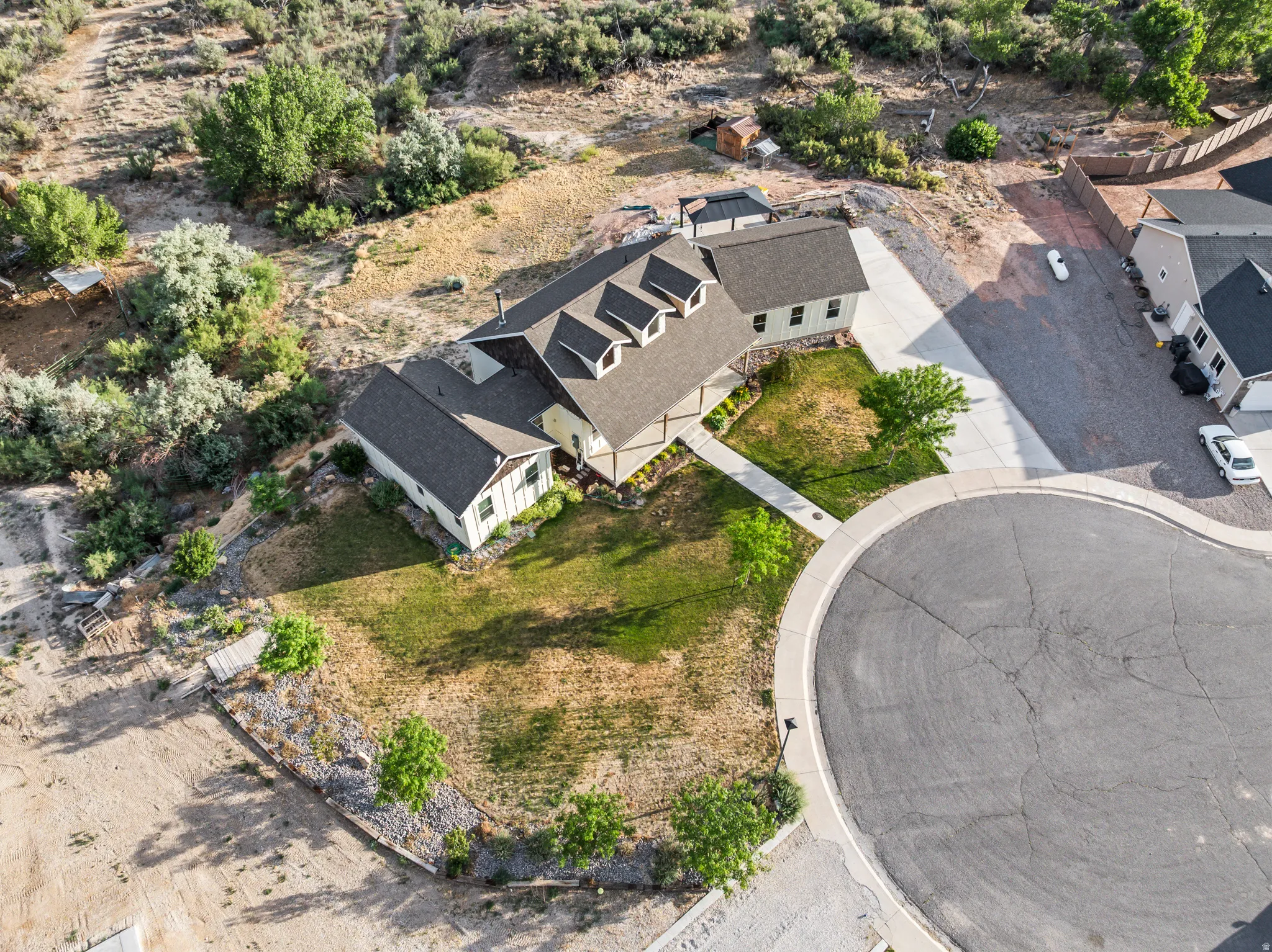Contemporary home with dormer windows, a concrete driveway, and a cul-de-sac