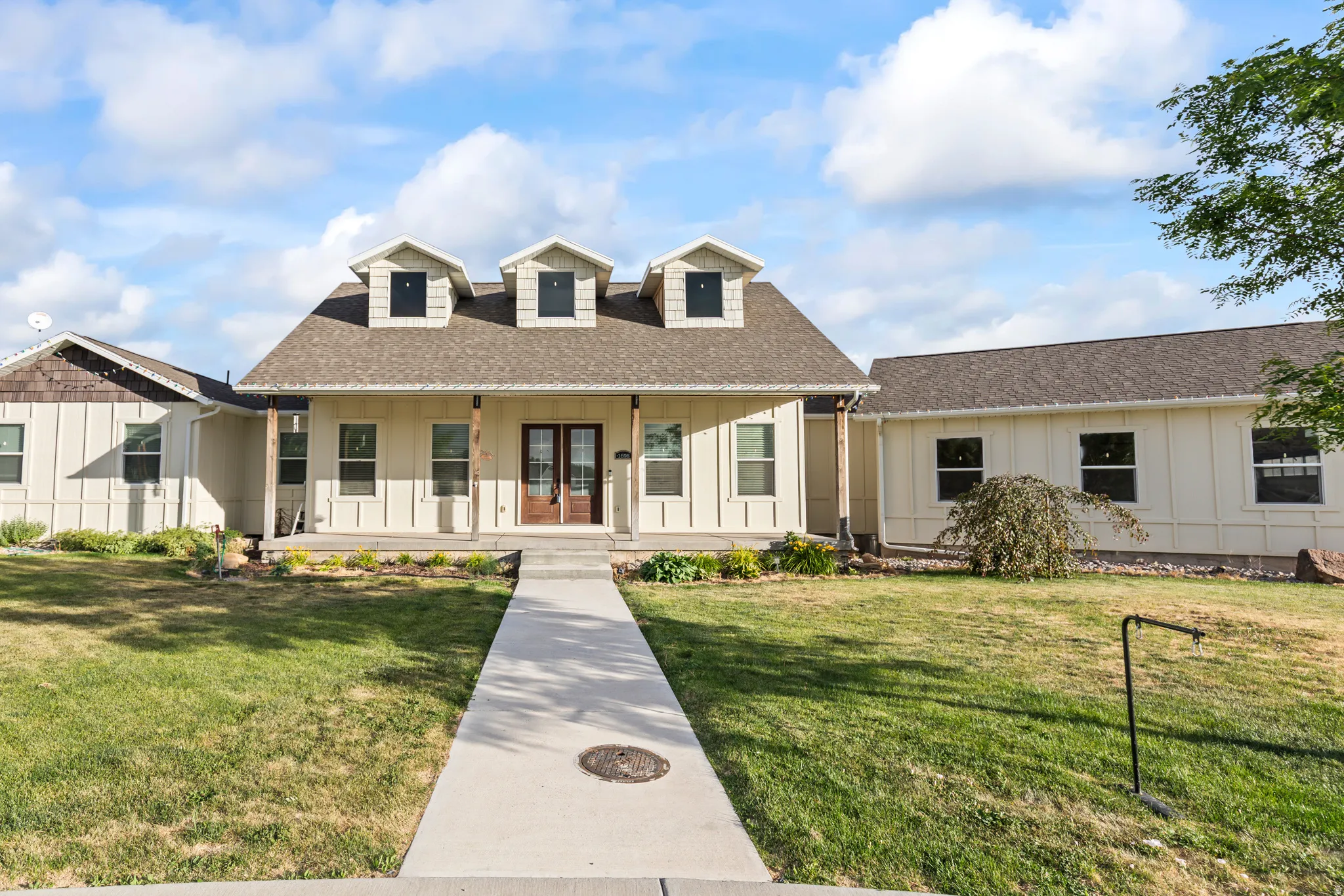 Light-toned exterior with a covered front porch supported by wood columns