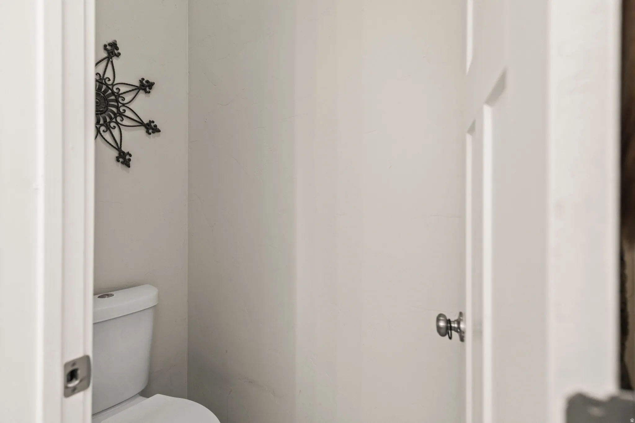 White wall finishes and a standard toilet fixture