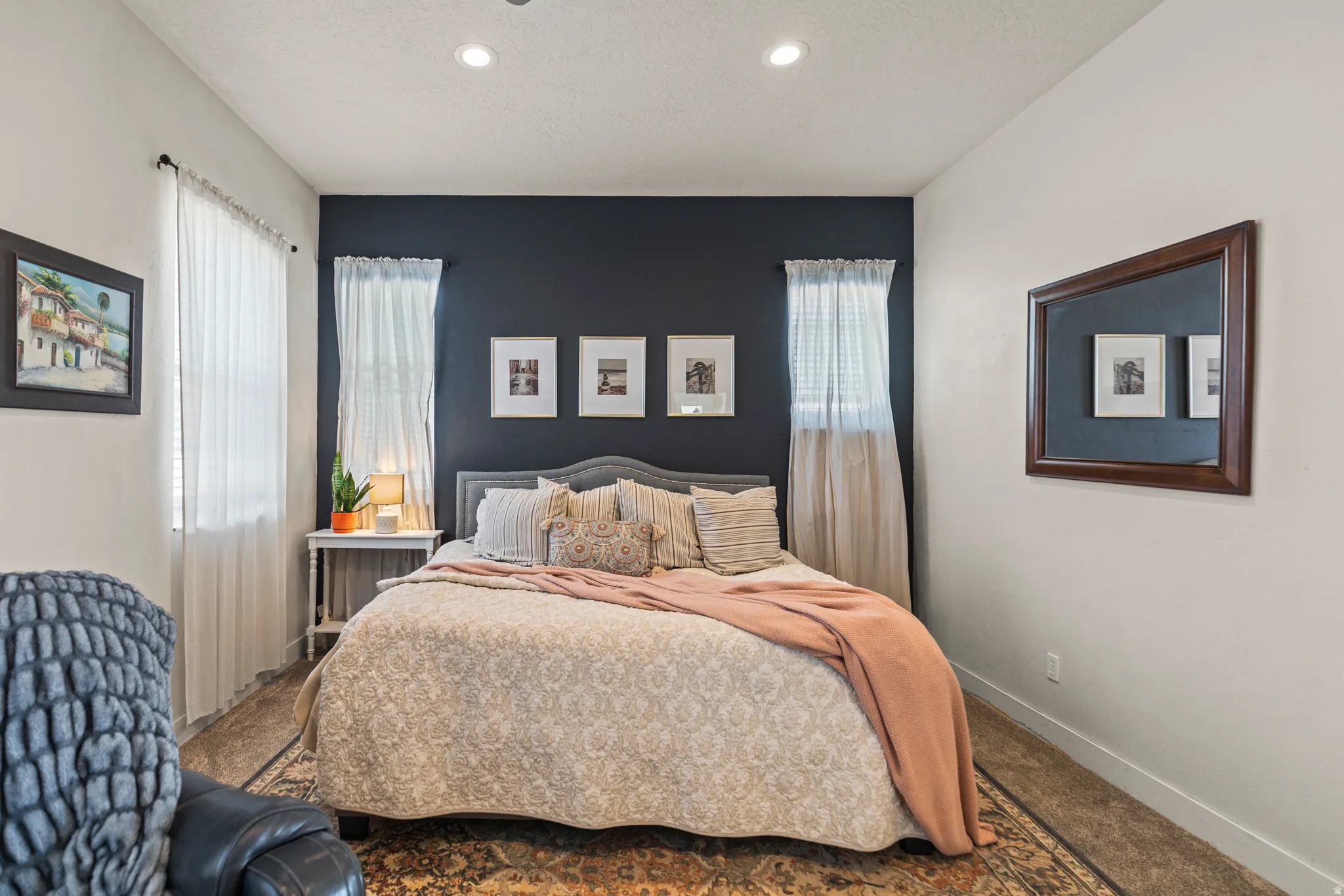 Bedroom featuring a dark accent wall, white walls, recessed ceiling lighting, and carpet flooring