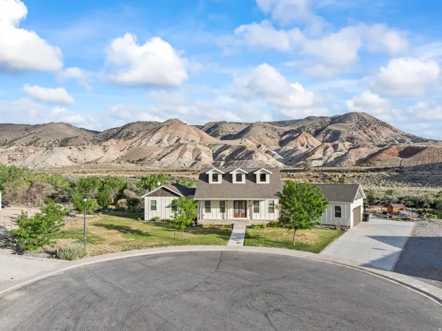 Single-story home featuring dormer windows, a covered front porch, and a concrete driveway