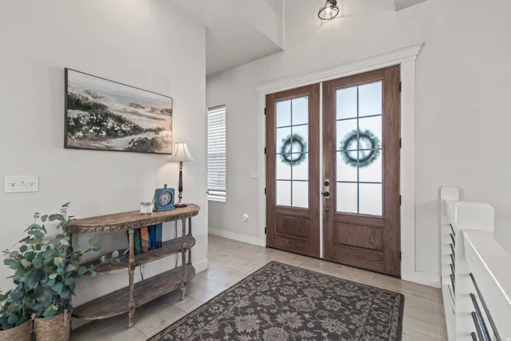 Double wood-finish entry doors with frosted glass panels and grid accents