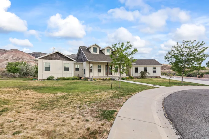 Contemporary residence featuring dormer windows, a covered front porch with pillar supports, and a shingled roof