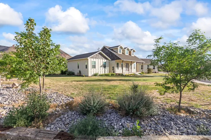 Ranch-style exterior with board and batten siding, multiple dormer windows, and a covered porch