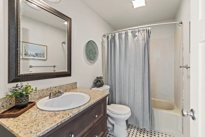 Bathroom featuring a dark wood vanity with a granite-style countertop and an undermount sink