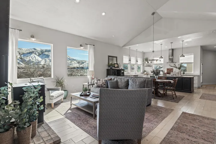 Open-concept living area featuring a vaulted ceiling and expansive windows showcasing mountain scenery