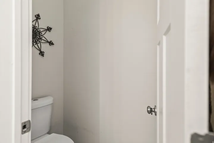White wall finishes and a standard toilet fixture