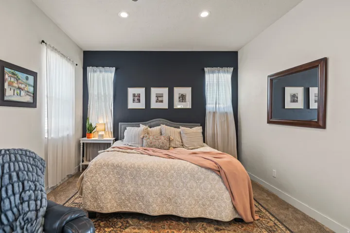 Bedroom featuring a dark accent wall, white walls, recessed ceiling lighting, and carpet flooring