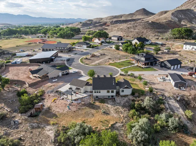 Residential community featuring a cul-de-sac with multiple single-family homes, diverse architectural styles, and an undeveloped lot