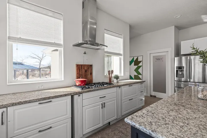 Kitchen featuring white cabinetry, speckled countertops, and stainless steel appliances