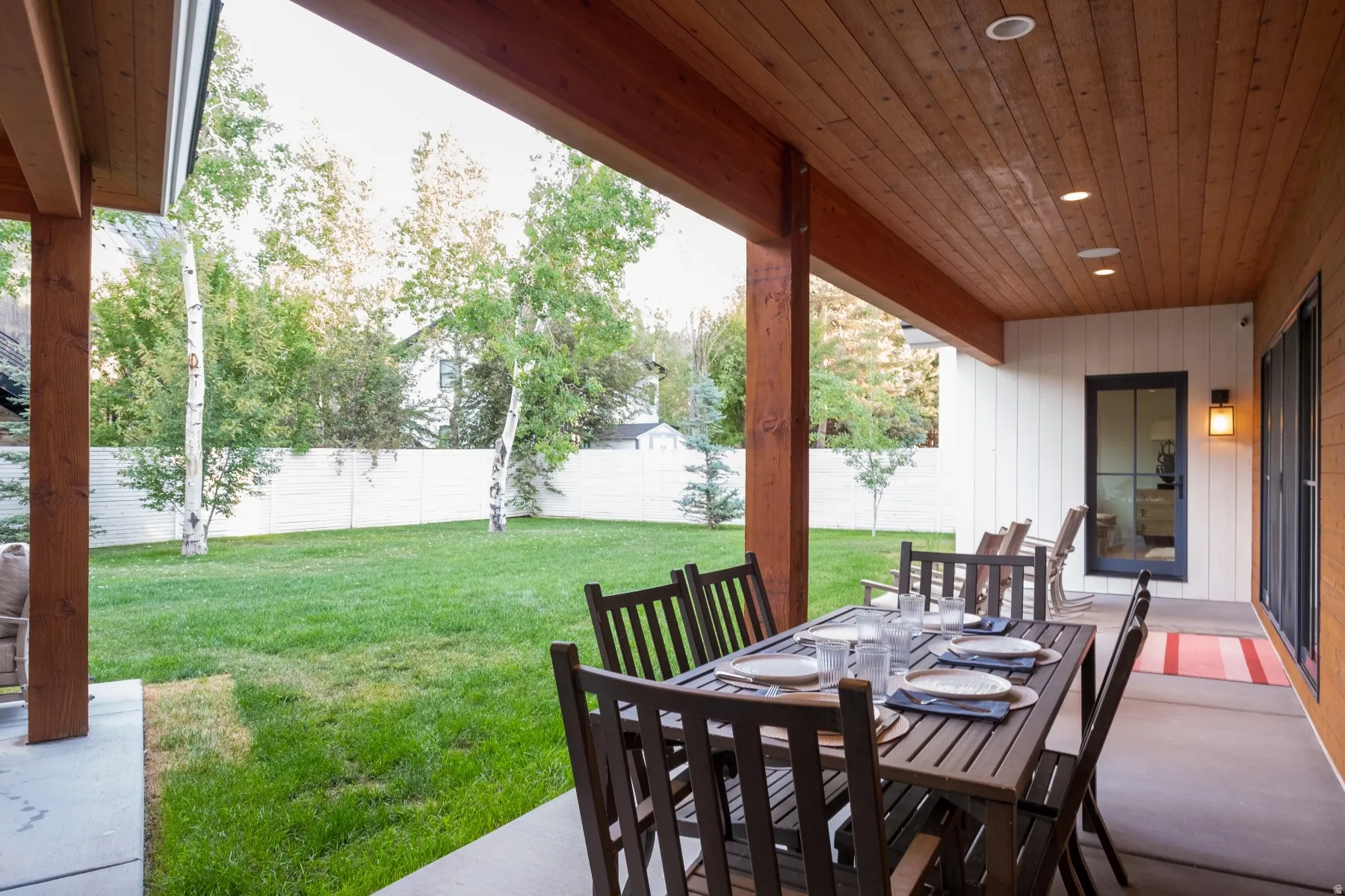 Covered patio with a wood-finish ceiling, recessed lighting, and support beams