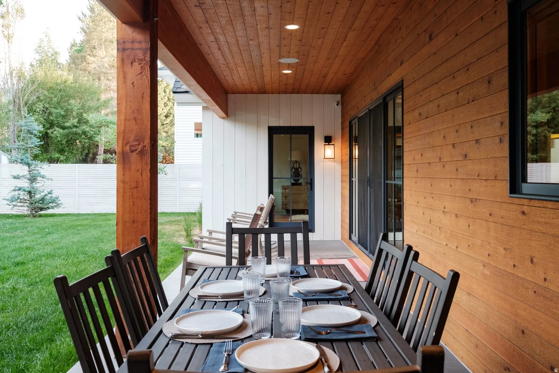 Covered outdoor patio featuring a wood plank ceiling with recessed lighting and a large wood support beam