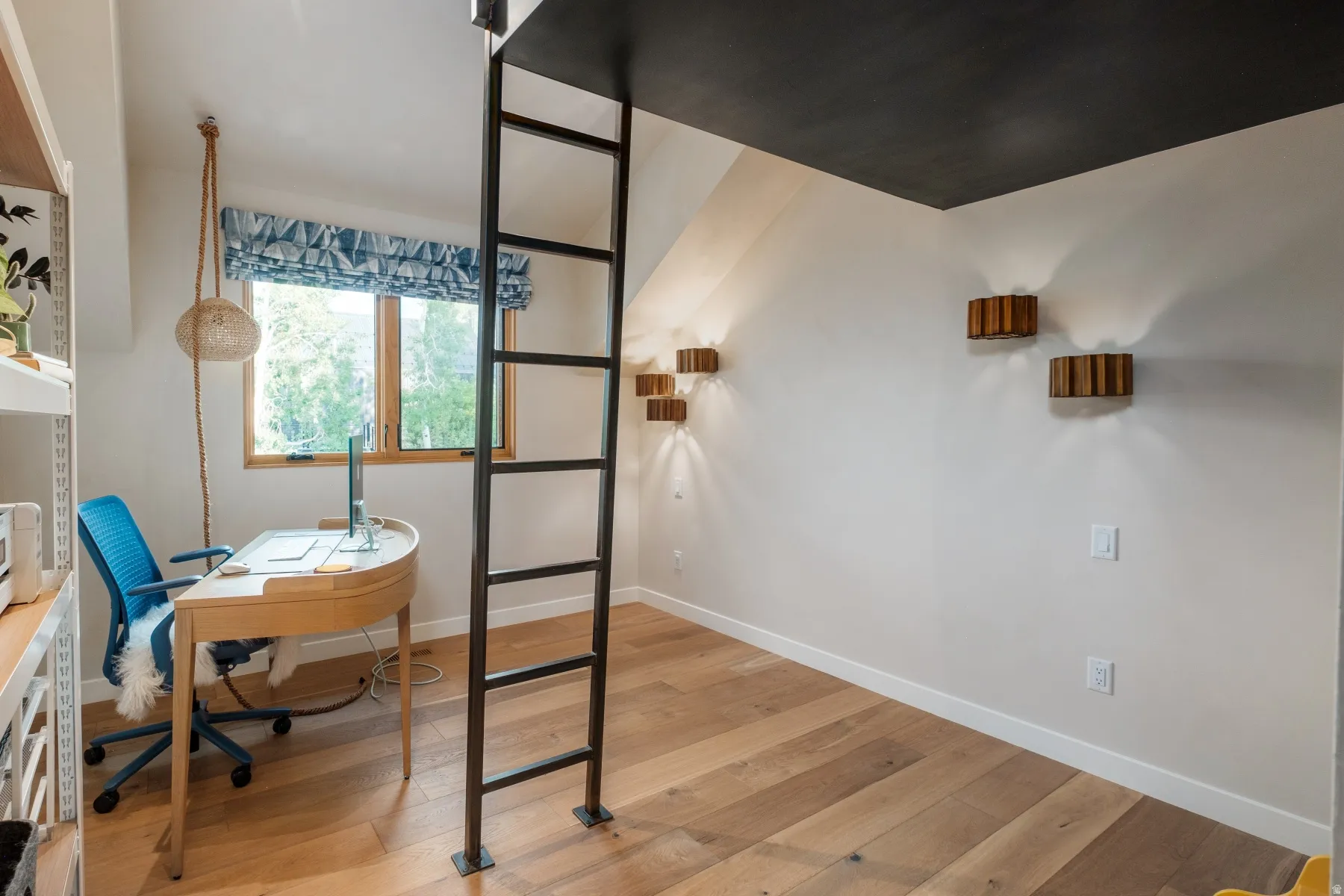 Light wood-finish flooring, a built-in ladder, and a black ceiling detail