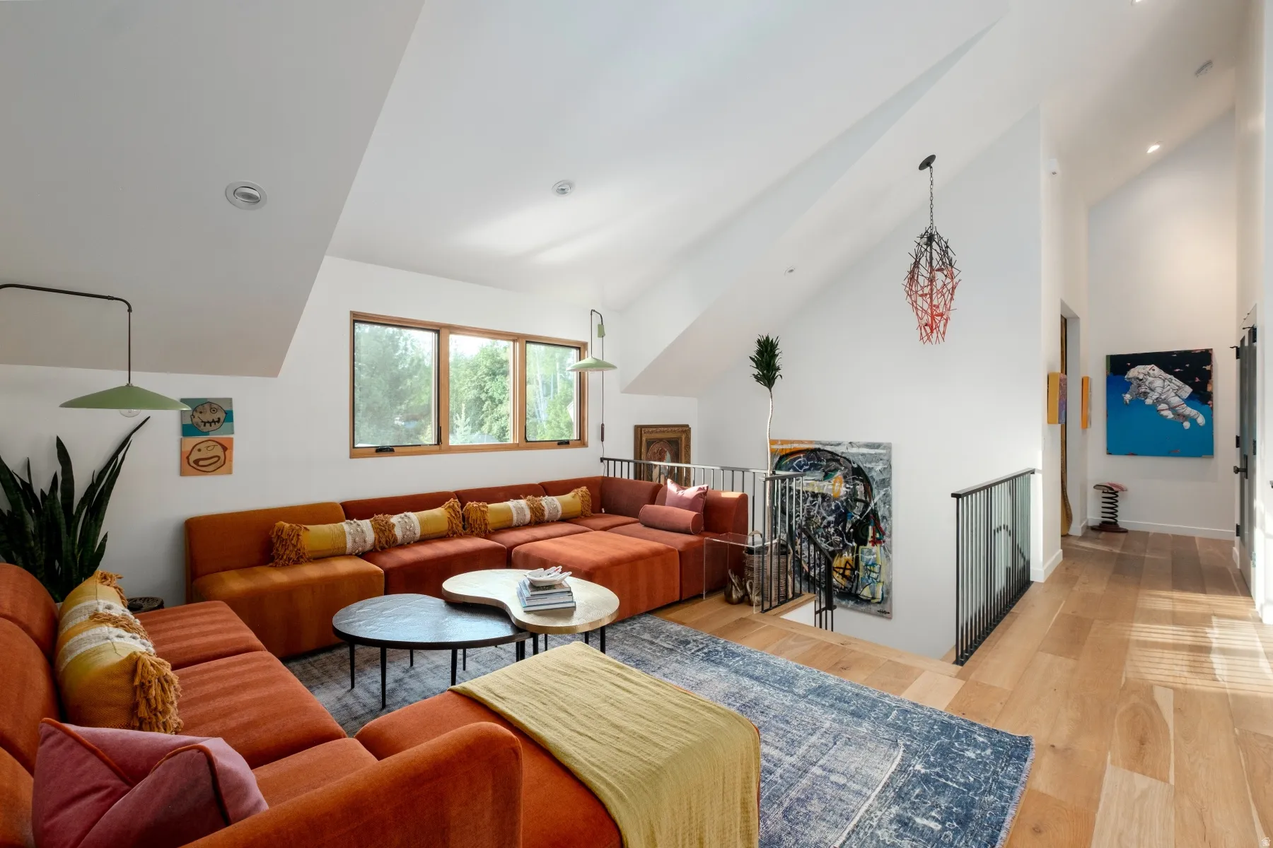 Vaulted ceilings enhance this open-concept living area featuring wood-finish flooring