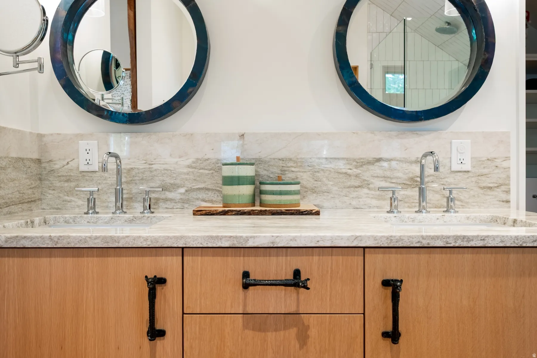 Dual circular mirrors with textured blue frames above a double vanity