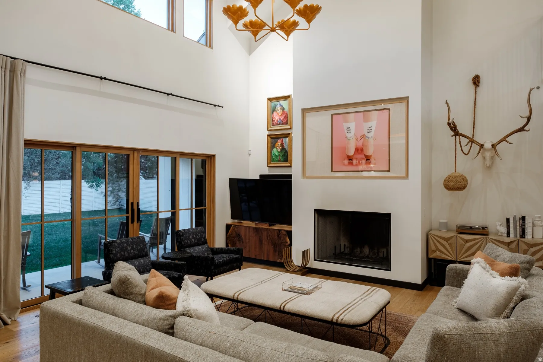 Living area featuring vaulted ceilings, a contemporary fireplace, and wood-finish flooring