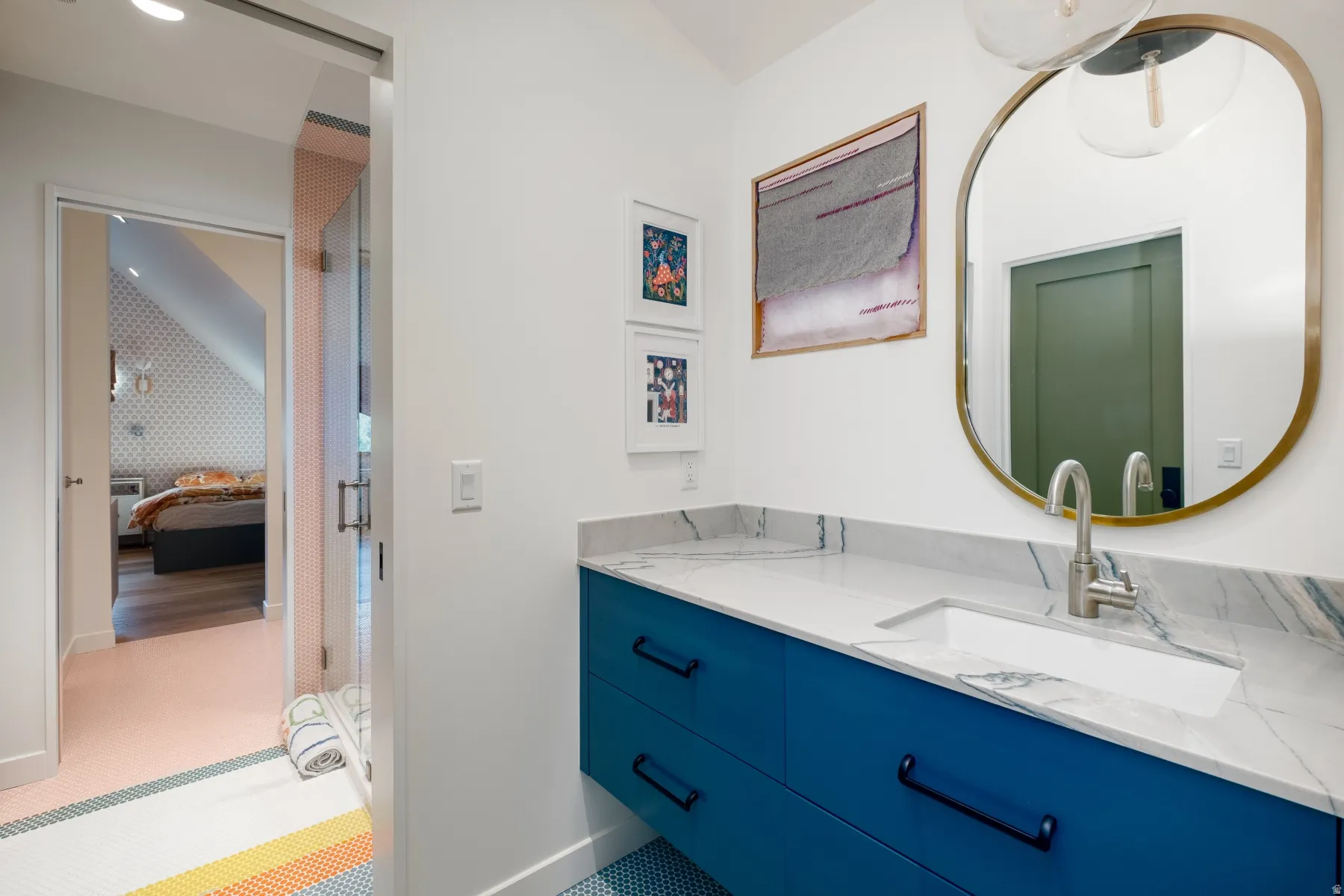 Bathroom vanity featuring a vessel sink, stone countertop, and blue cabinetry with black hardware