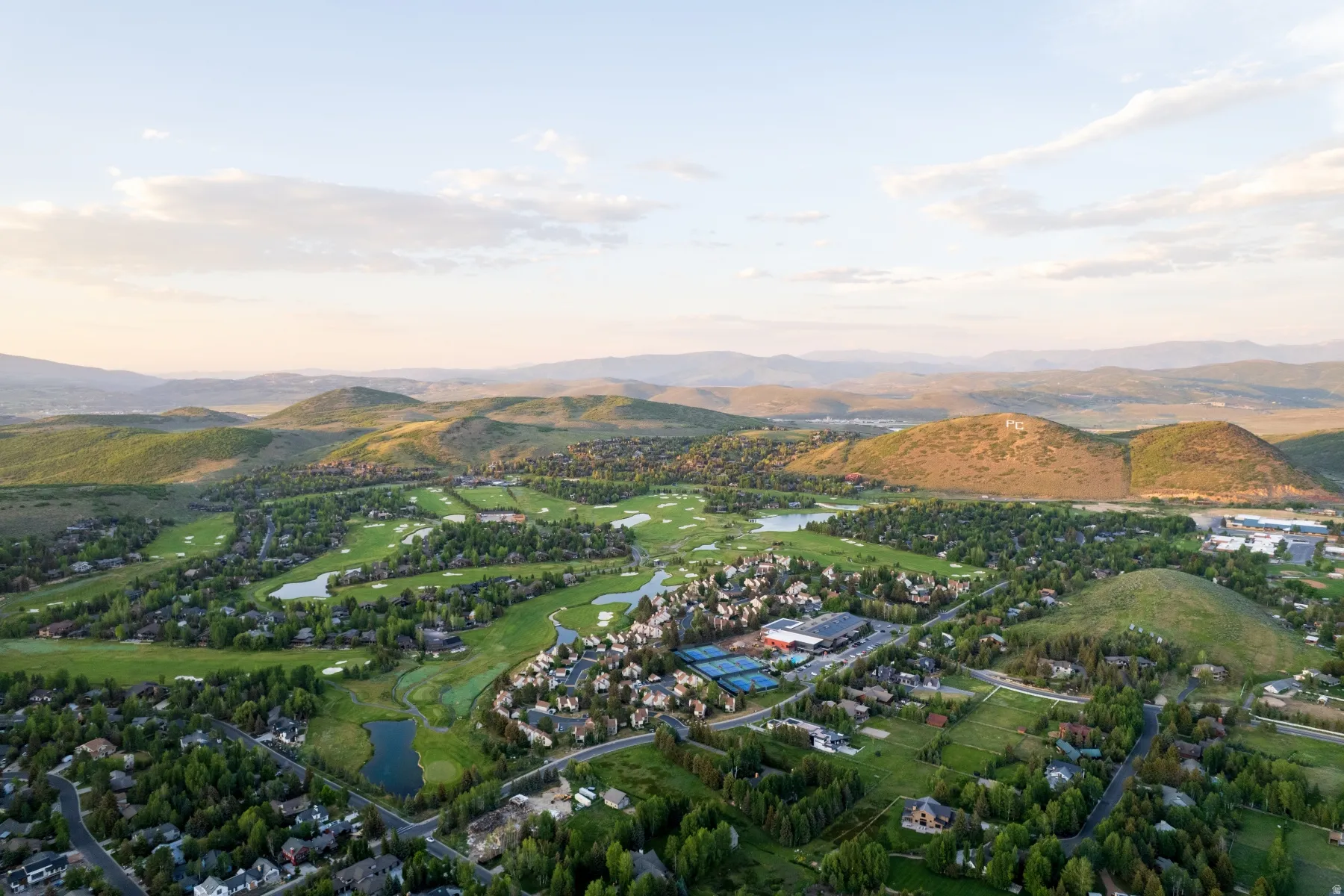 Expansive aerial perspective showcasing a golf course community with numerous residential properties
