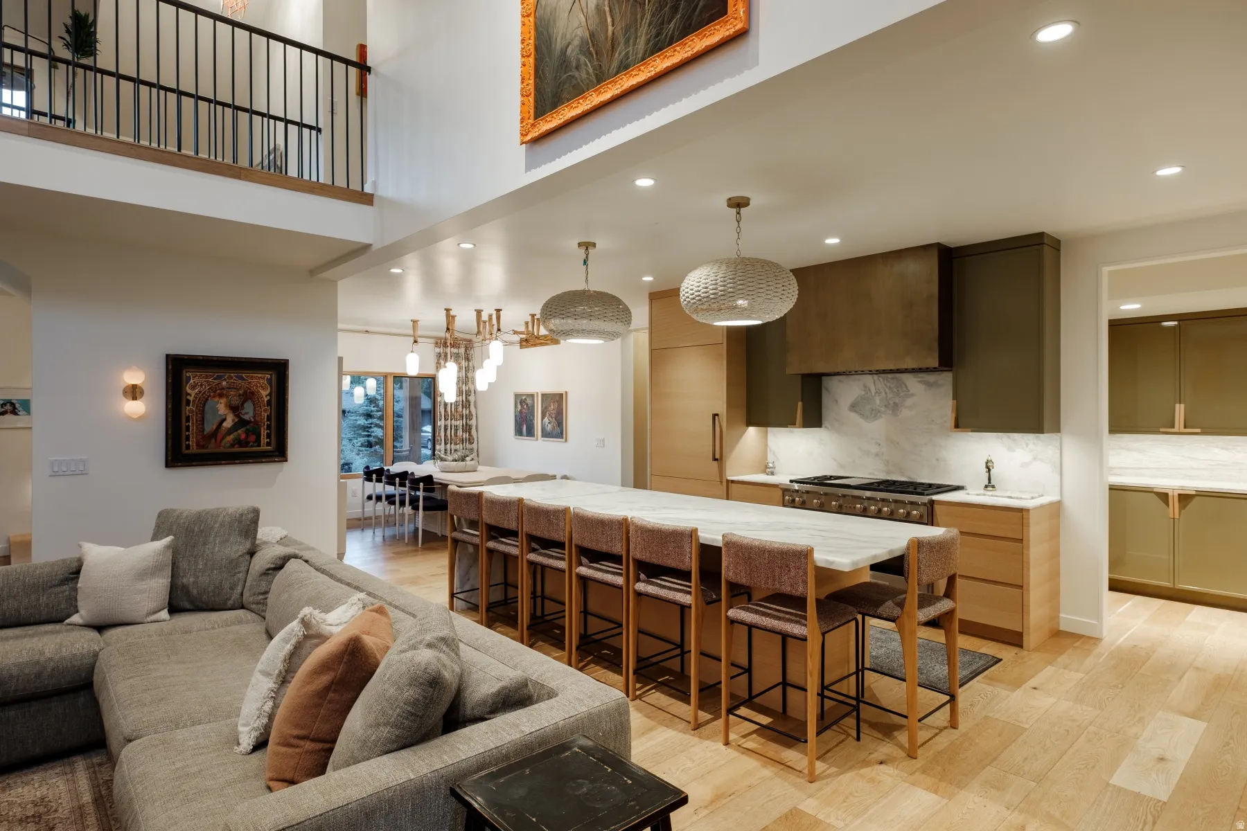 Open-concept kitchen featuring a large island with seating, a professional-grade range, and a custom range hood
