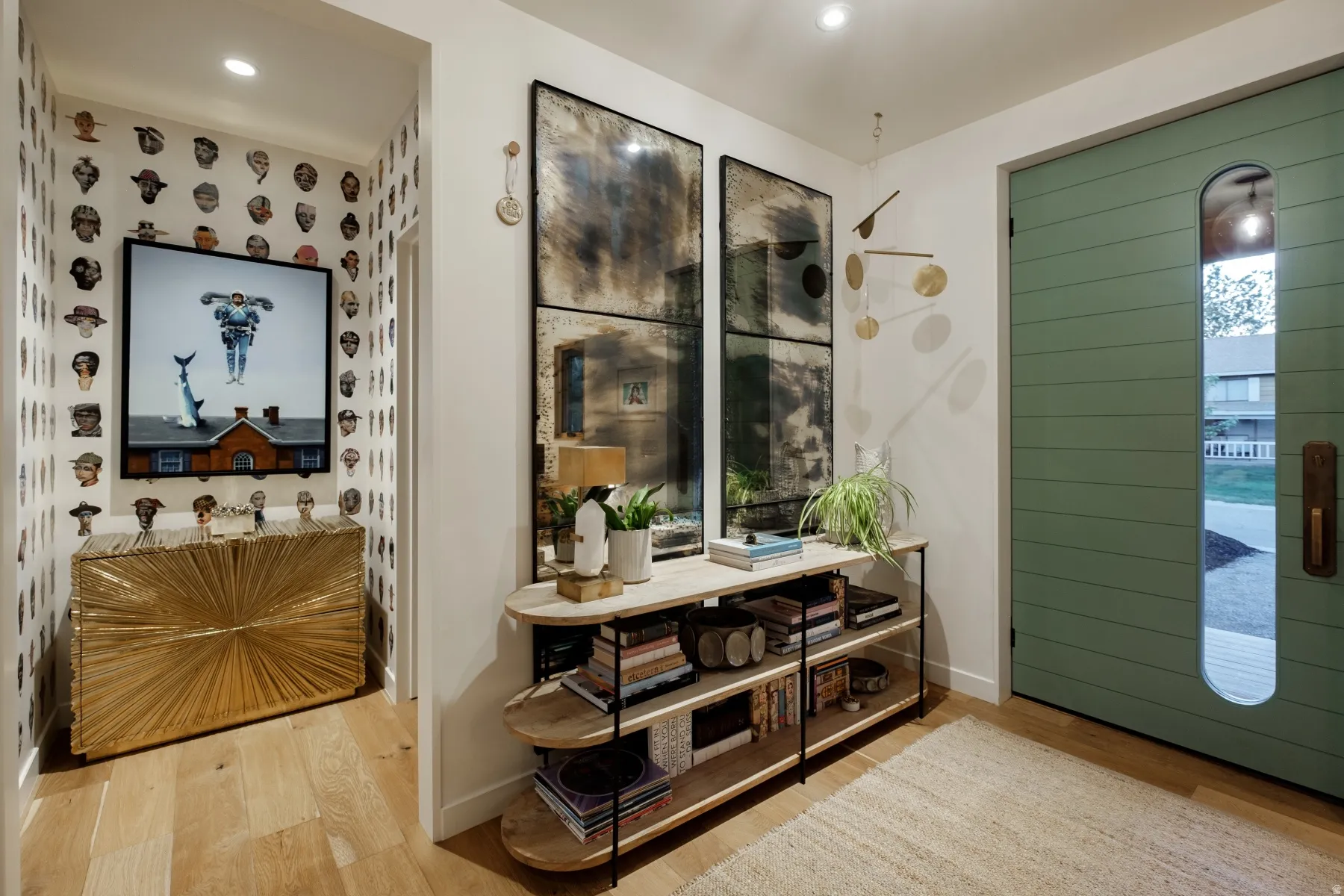 Entryway featuring a green paneled door with an arched window, light wood-finish flooring, and recessed lighting