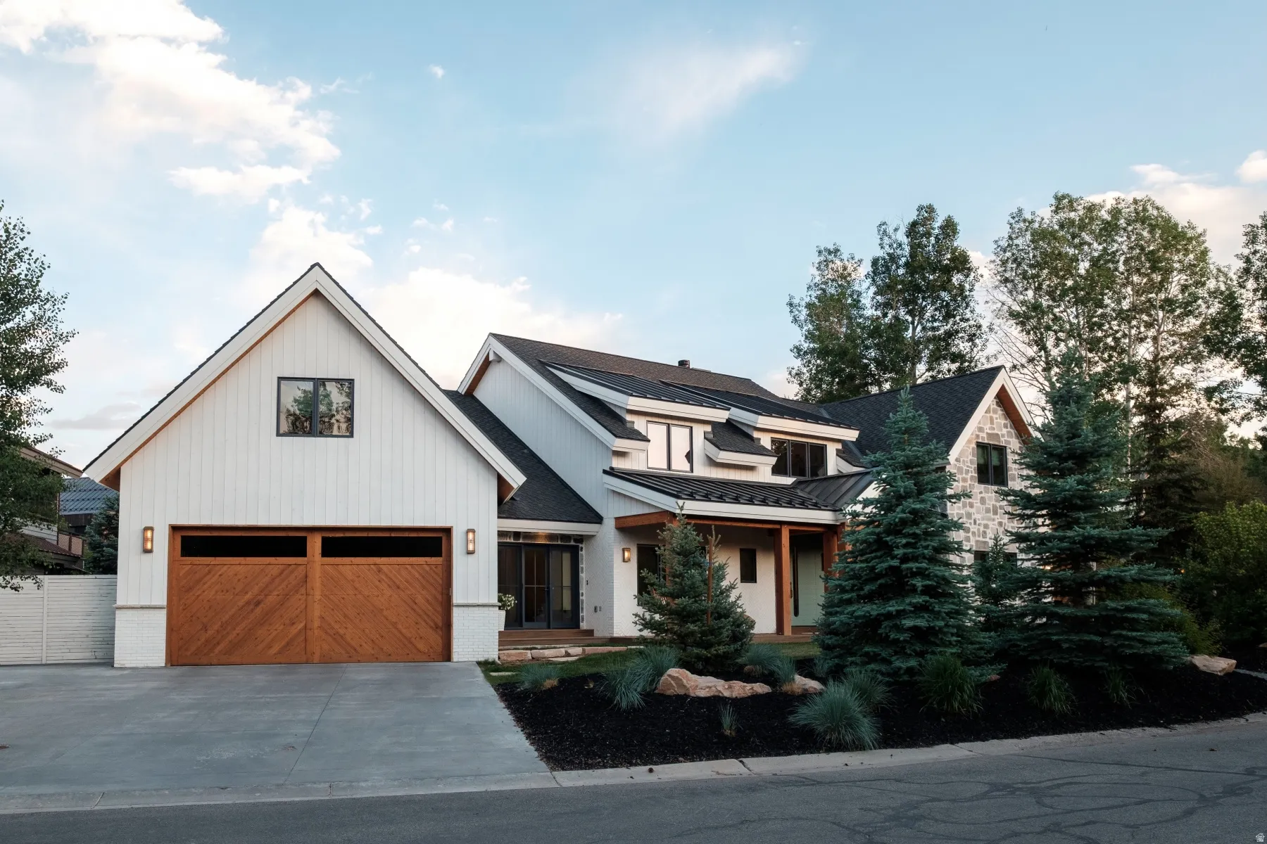 Contemporary architectural design with white board-and-batten siding and stone accents