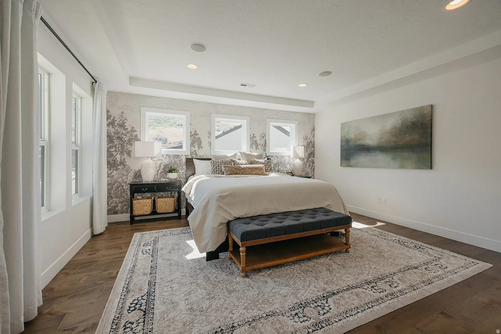 Spacious room featuring wood-finish flooring, a tray ceiling, and recessed lighting