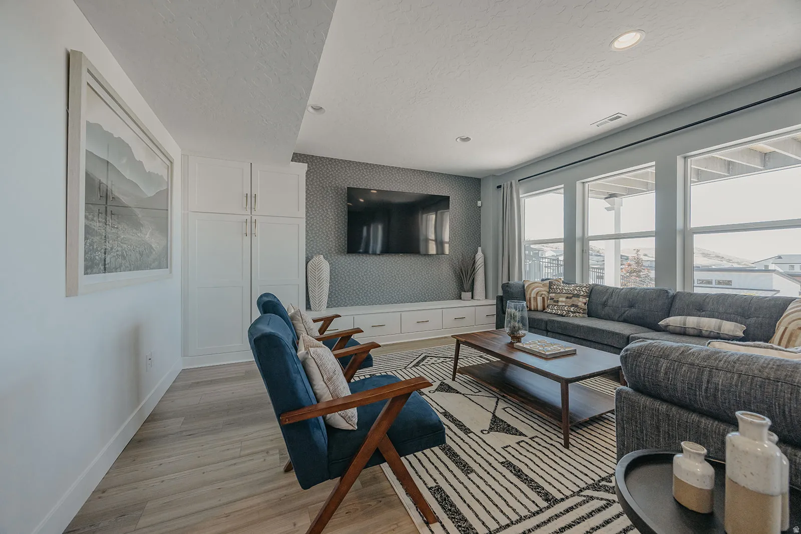 Living area featuring wood-finish flooring, recessed lighting, and a wall of windows