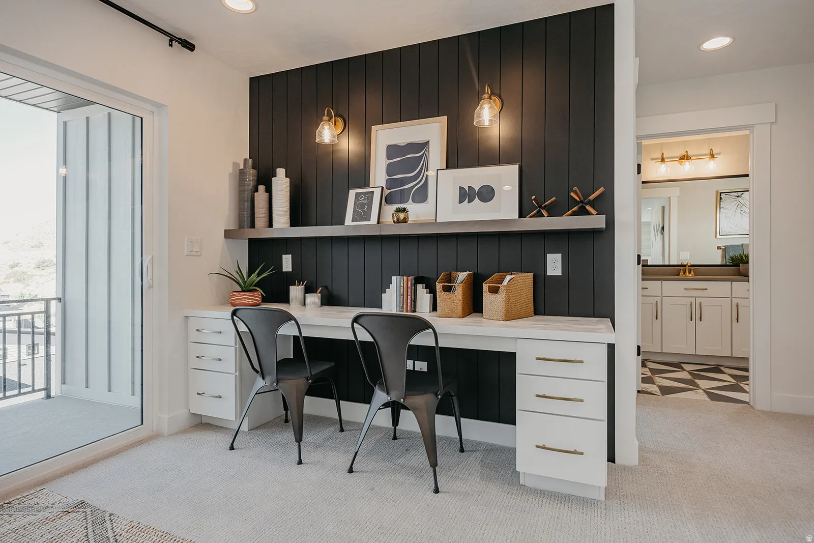 Built-in desk featuring a shiplap accent wall, wall-mounted sconces, and overhead shelving