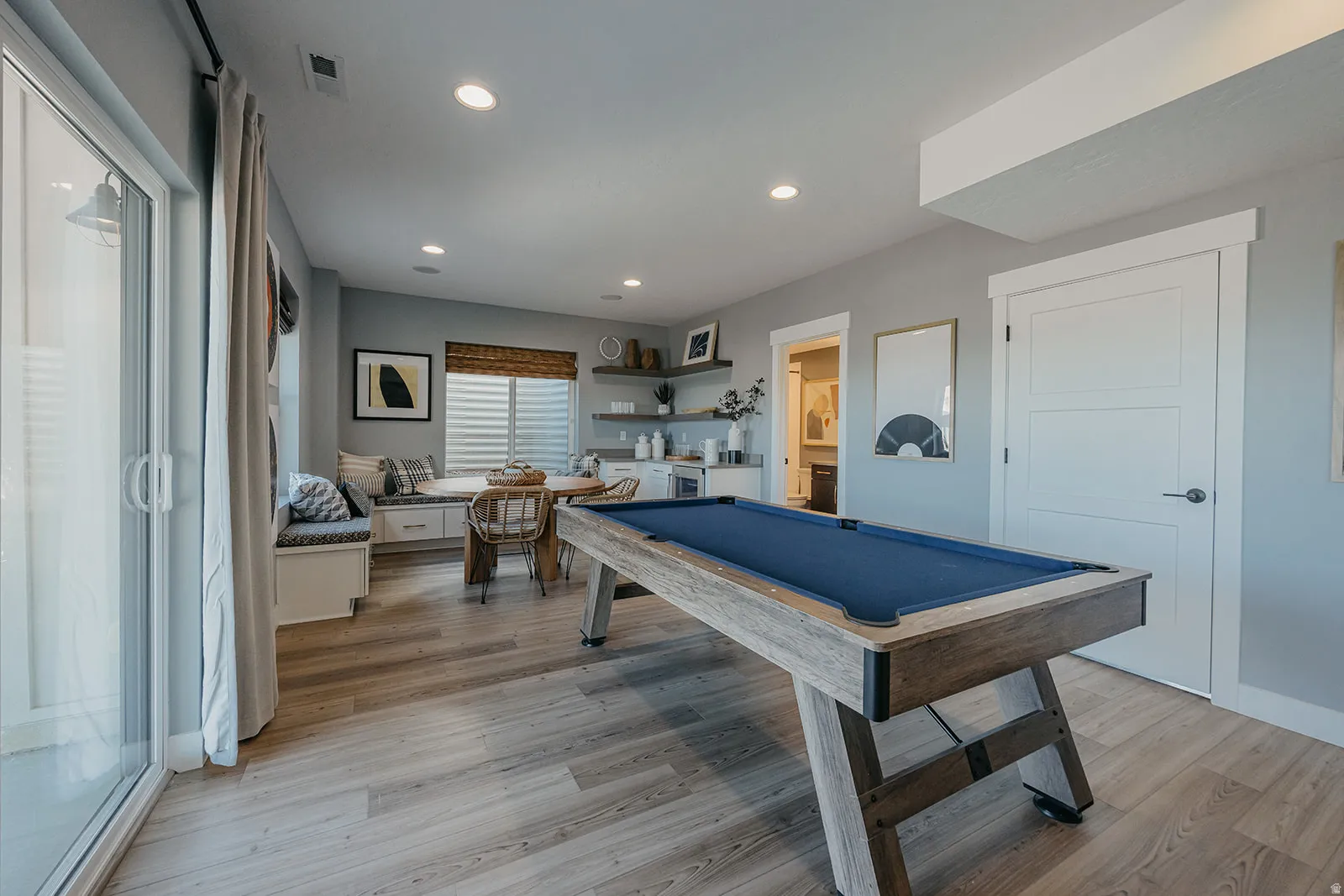 Spacious recreation room featuring wood-finish flooring and recessed lighting