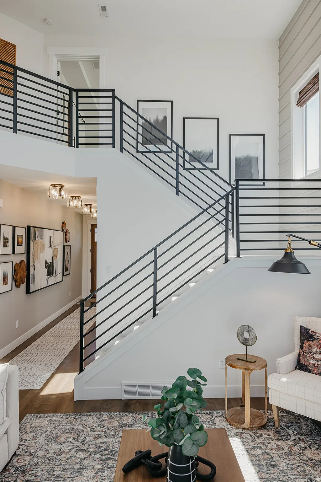 Two-story interior with prominent open staircase featuring black metal railings and white risers
