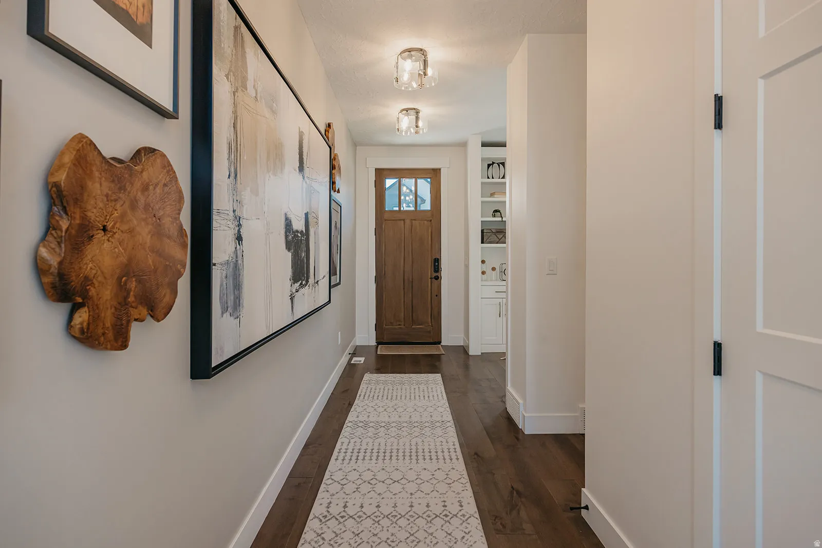 Hallway featuring wood-finish flooring, recessed lighting, and a solid wood entry door with glass inserts