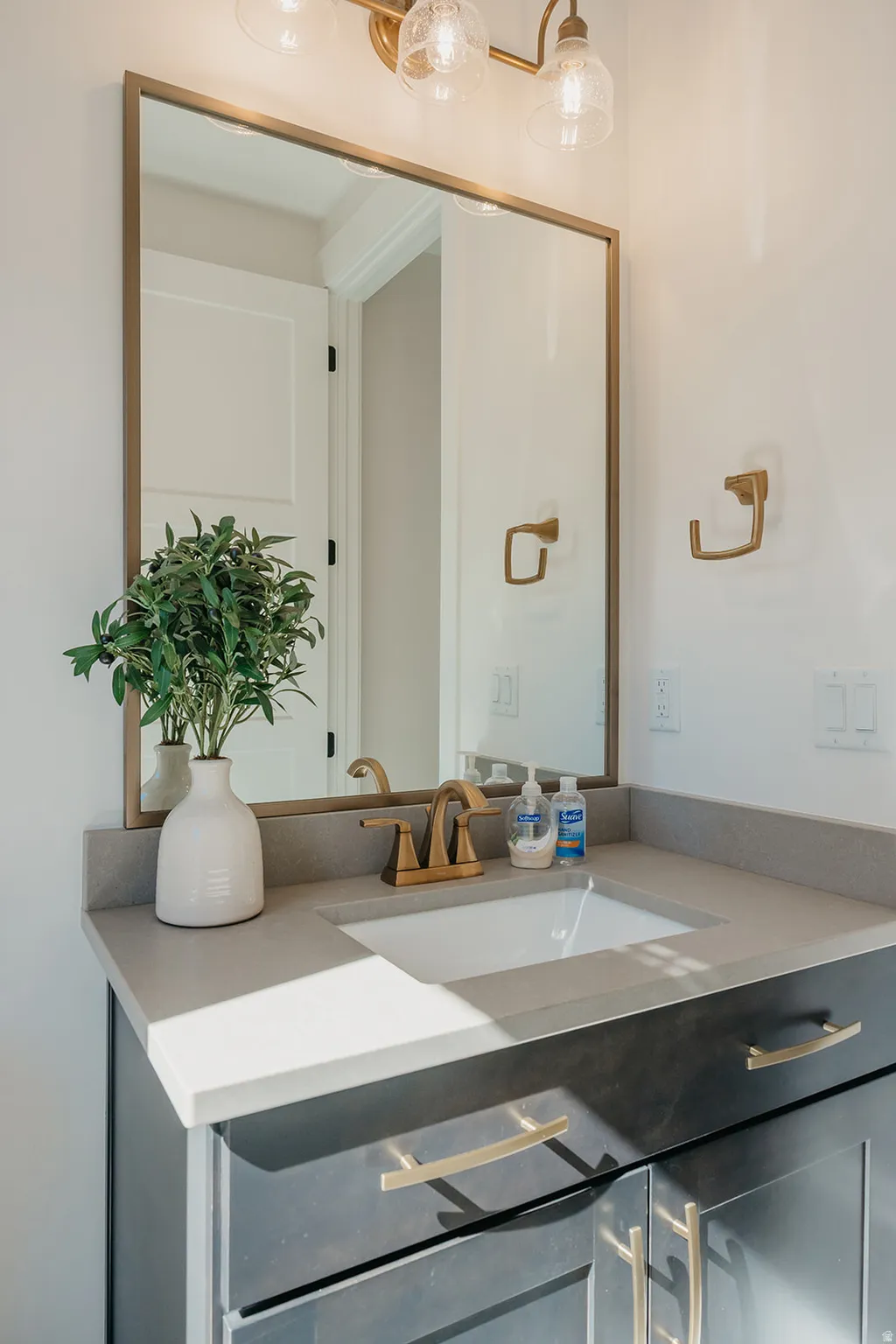 Bathroom vanity featuring a light gray countertop with an integrated rectangular sink