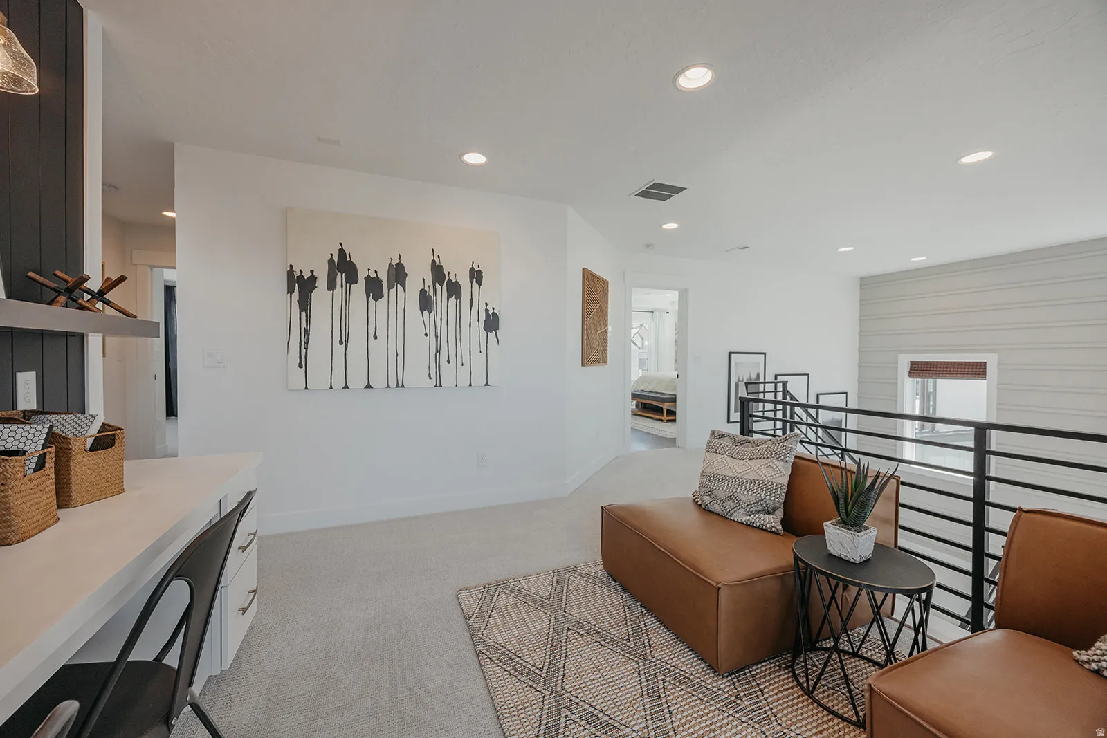 Open loft area featuring recessed lighting, a built-in desk, and a modern metal railing system