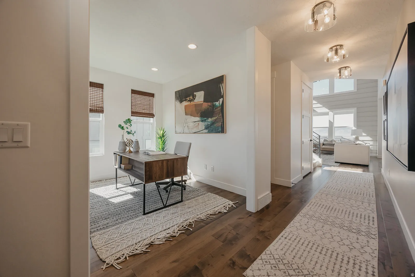 Versatile interior space featuring wood-finish flooring, recessed lighting, and large windows with woven shades