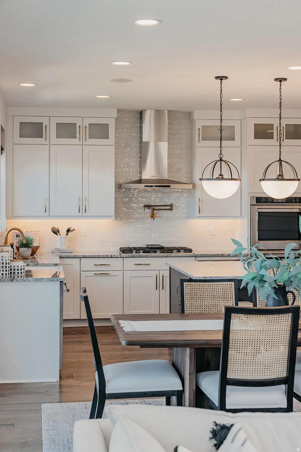 Modern kitchen featuring white shaker cabinetry, stainless steel appliances, a tile backsplash, and recessed lighting